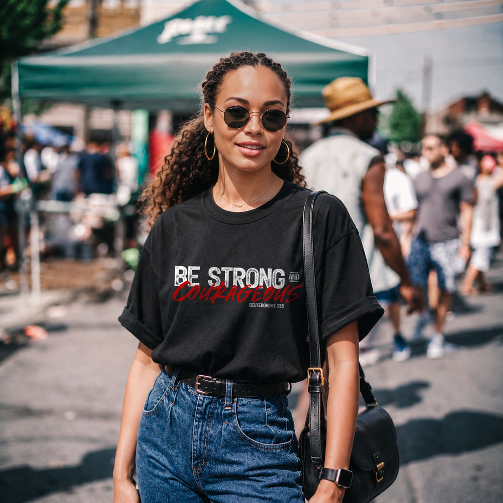 Unisex softstyle T-shirt with "Be Strong and Courageous" print in black on a white fabric, casual and comfortable clothing.