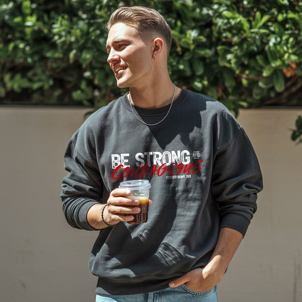 Unisex midweight softstyle fleece crewneck sweatshirt with "Be Strong and Courageous" print, by Printify, showcasing a comfortable fit and design.