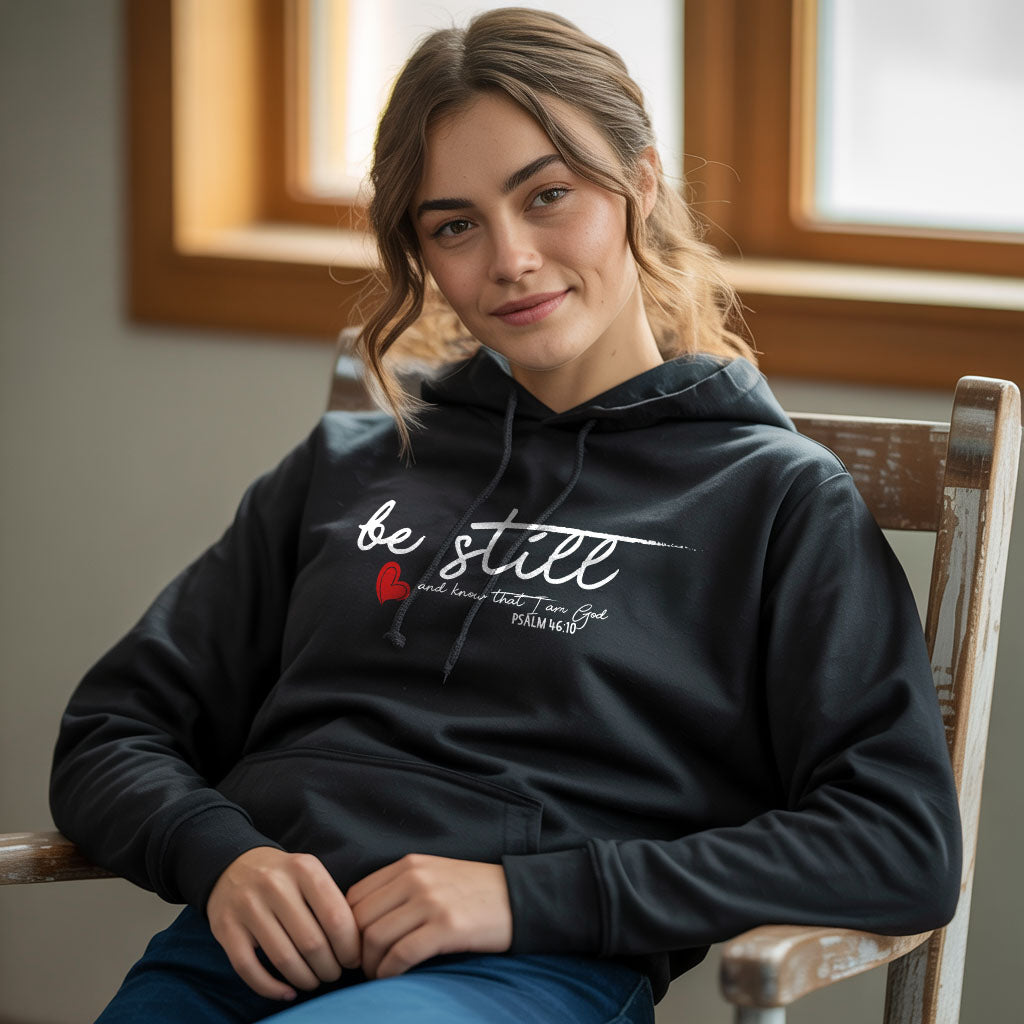 Unisex Heavy Blend™ hoodie with "Be Still" print, in black, showing front view with hood and drawstrings.